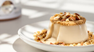 découvrez notre délicieuse panna cotta au thé hojicha, sublimée par un topping croustillant de crumble aux amandes, alliant douceur et saveurs raffinées.